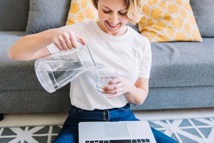 smiling-woman-with-laptop-pouring-water_23-2147765048.jpg
