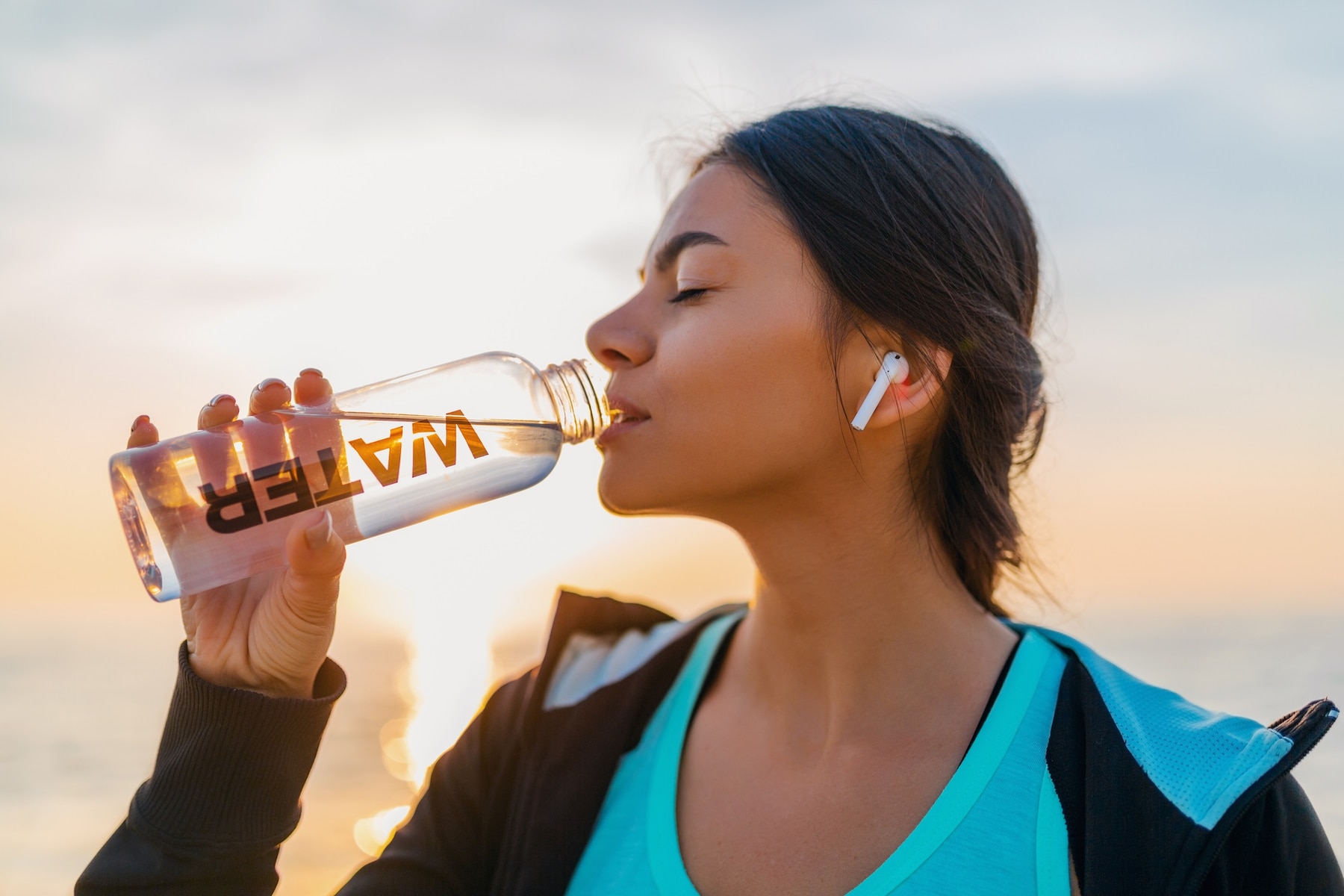 attractive-slim-woman-doing-sport-exercises-morning-sunrise-beach-sports-wear-thirsty-drinking-water-bottle-healthy-lifestyle-listening-music-wireless-earphones-smiling-happy_285396-5555.jpg