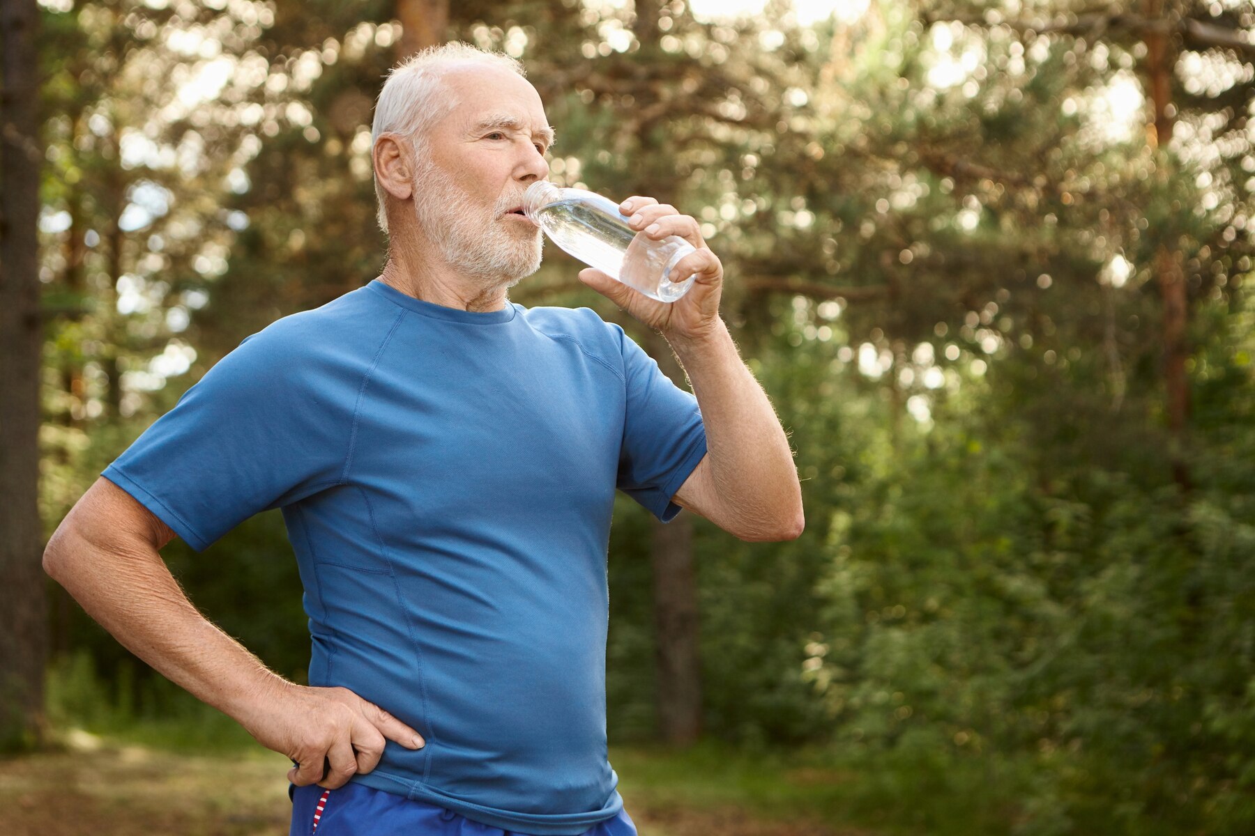 portrait-of-attractive-active-male-pensioner-with-bald-head-and-stubble-refreshing-himself-after-jogging-outdoors-standing-against-pine-forest-holding-bottle-of-drinking-water_343059-4755.jpg