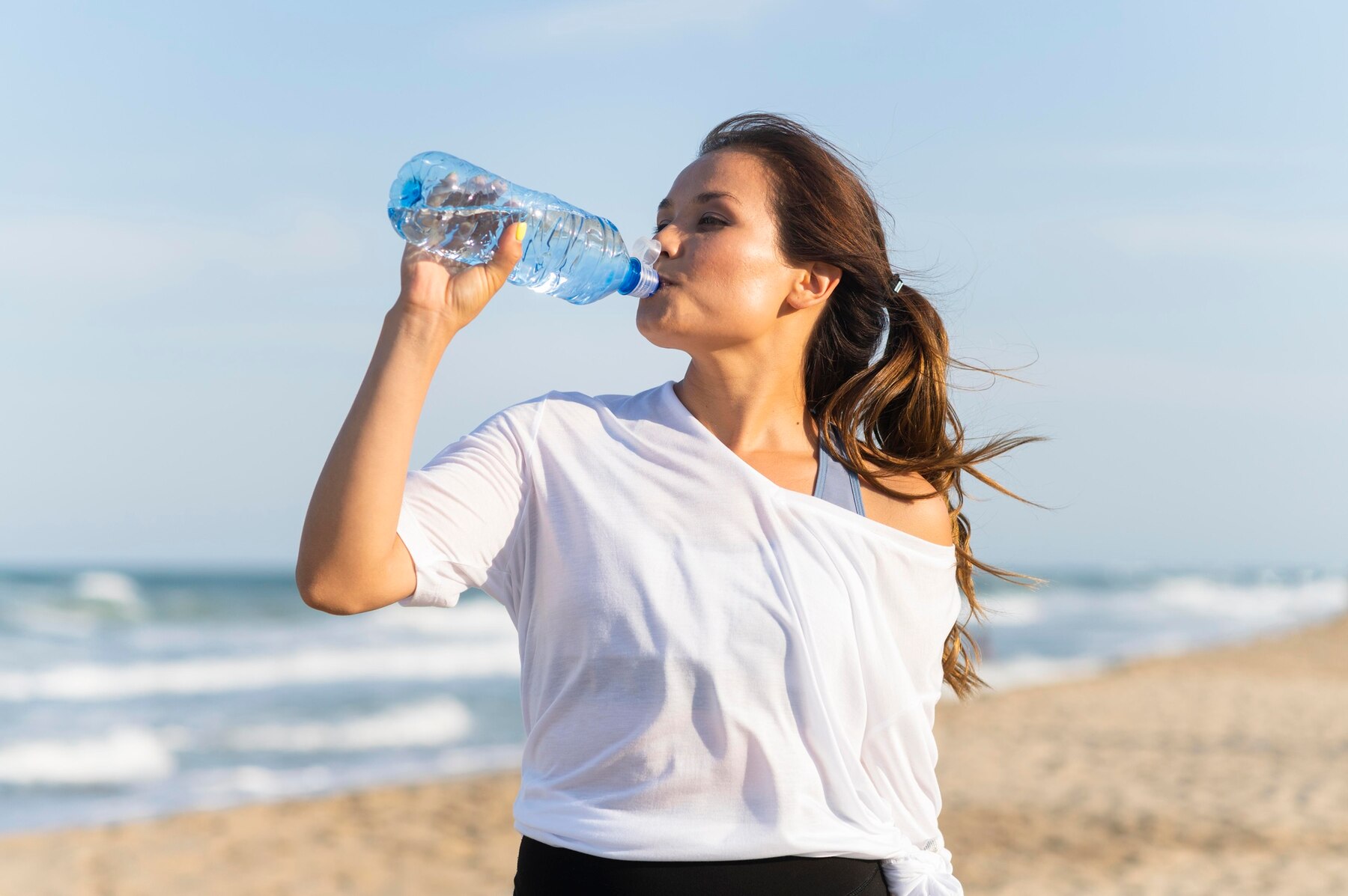 woman-drinking-water-on-the-beach-while-working-out_23-2148694906.jpg