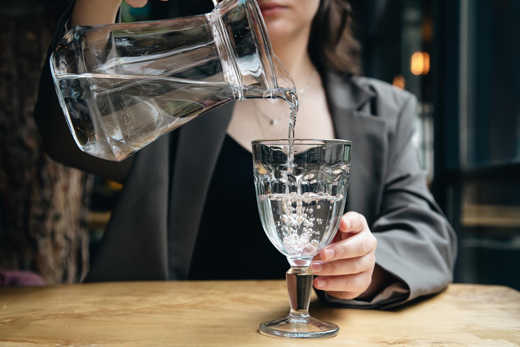 closeup-a-woman-pours-water-into-a-glass-in-a-cafe_169016-21808 (1).jpg