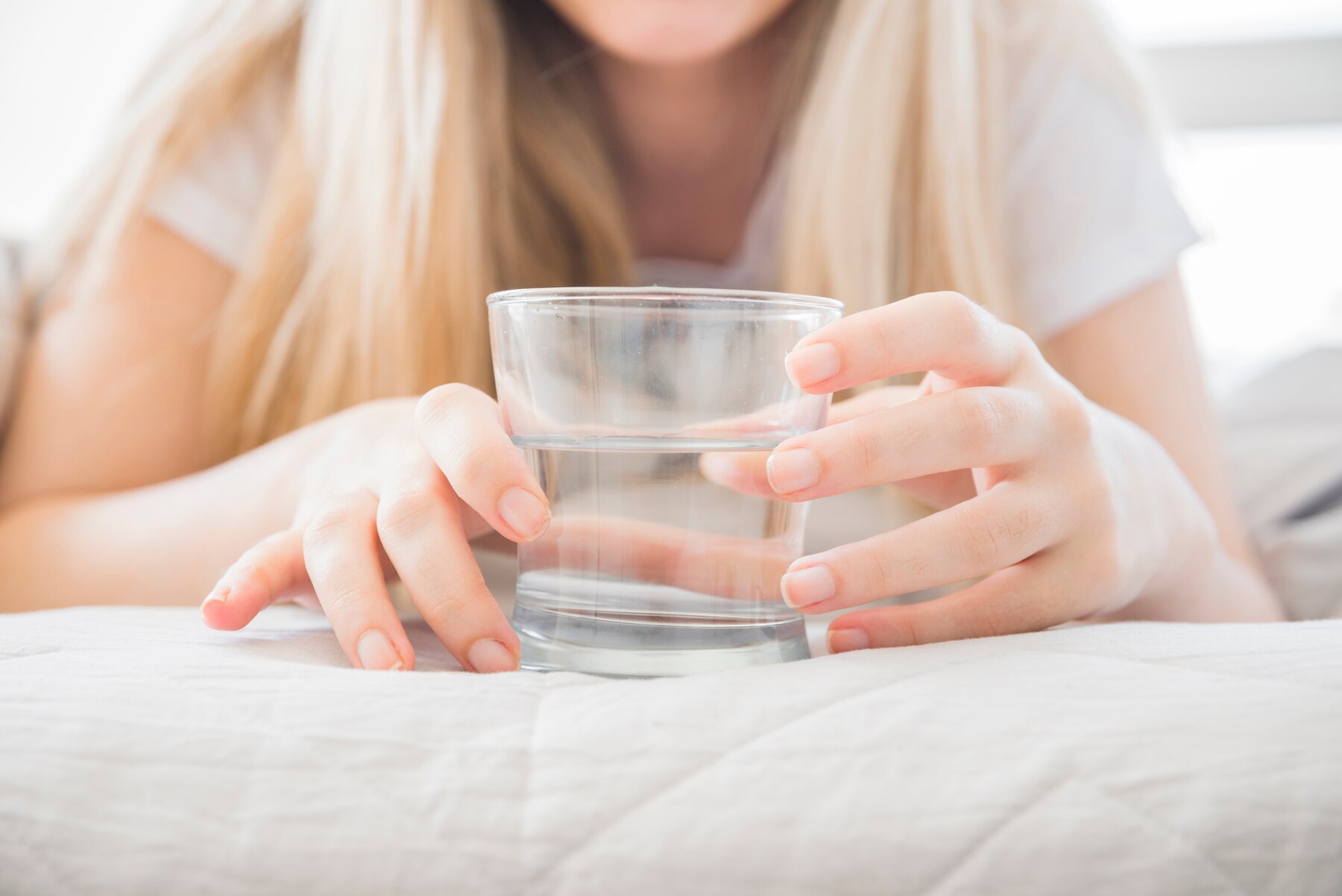 blonde-girl-holding-glass-of-water-on-the-bed_23-2148113498 (1).jpg