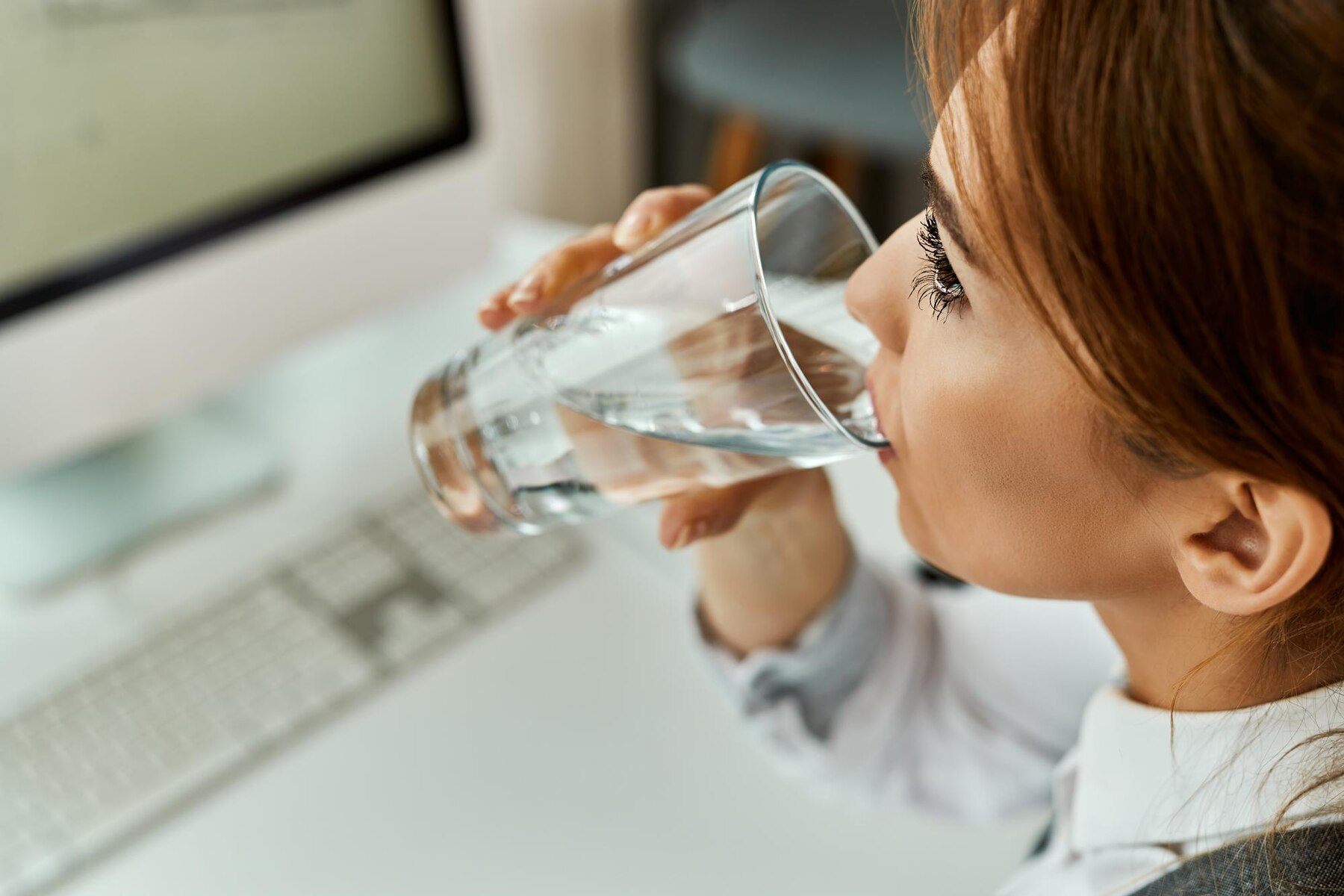 closeup-of-businesswoman-having-a-glass-of-water-while-working-un-the-office_637285-5440.jpg